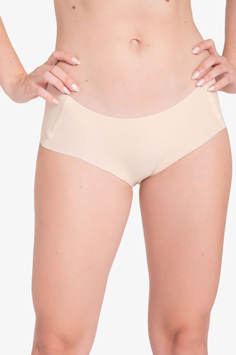 Primer plano de ropa interior beige sin costuras para mujer, piel clara, fondo blanco