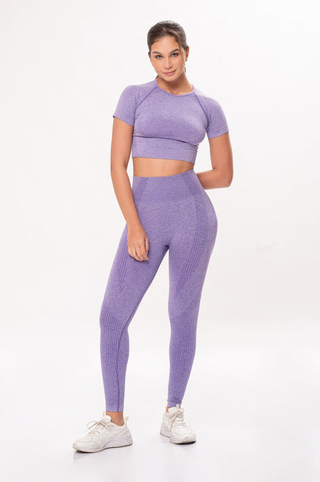 Mujer con ropa deportiva lavanda ajustada y zapatillas blancas en fondo blanco