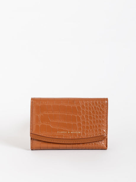 Cartera marrón de cuero con textura de cocodrilo y frase Classic & Modern en frente