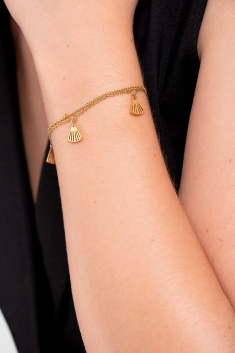 Brazalete dorado doble cadena con colgantes en forma de abanico en brazo femenino